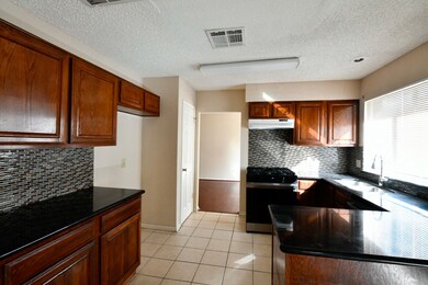 Luxurious granite countertops enhance the kitchen's elegance and durability.