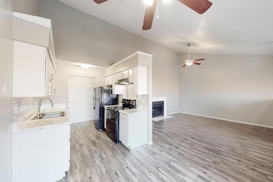 Kitchen with sink, backsplash, lofted ceiling, whi