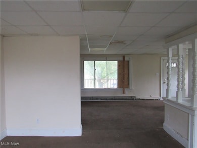 Spare room featuring baseboards and a paneled ceiling