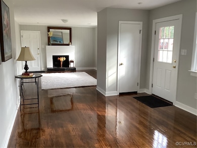 Entryway featuring baseboards, a lit fireplace, an