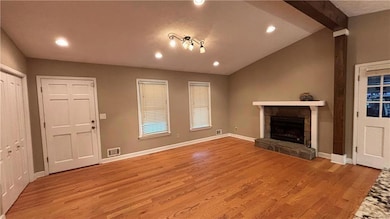 Unfurnished living room featuring a stone fireplace, light wood-type flooring, recessed lighting, and a textured ceiling
