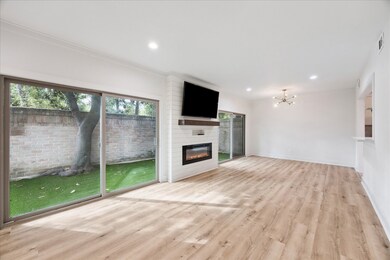 Two sliding glass doors access the fully fenced and newly turfed back green space.  Between them is a charming electric fireplace with rustic mantle and shiplap facade.