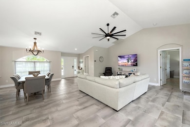 Living room featuring lofted ceiling, a chandelier