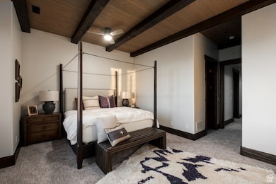 Carpeted bedroom featuring a wood ceiling with exposed beams