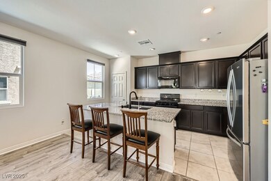 Kitchen with black appliances, a sink, light stone