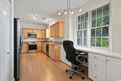 Office with sink, track lighting, and light hardwo