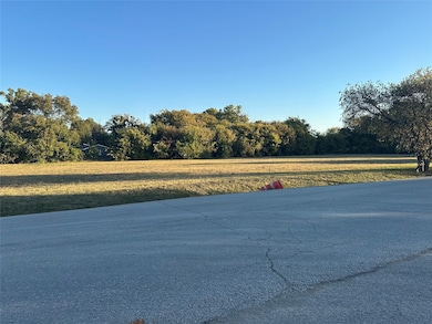 View of asphalt street featuring a view of trees