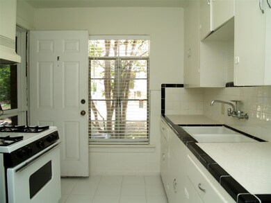 Kitchen featuring a sink, white cabinetry, decora