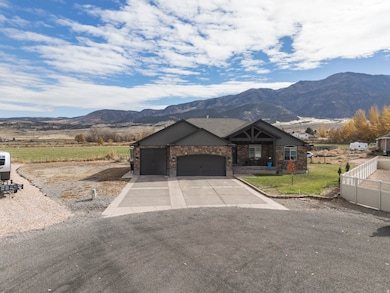 View of front of house with an attached garage, concrete driveway, and a mountain view