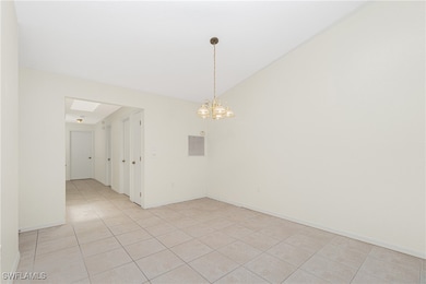 Empty room with light tile patterned floors, a cha