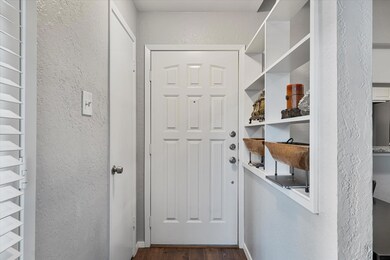Doorway with dark hardwood / wood-style floors