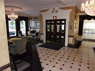 Tiled foyer entrance featuring ornamental molding and an inviting chandelier