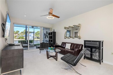 Carpeted living room featuring ceiling fan