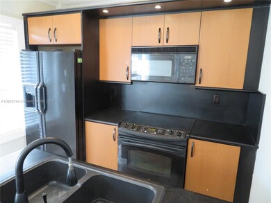 Nicely appointed kitchen with refrigerator, glass-top range, microwave and dishwasher
