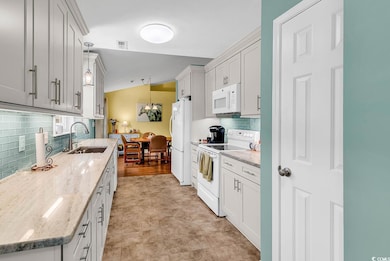 Kitchen featuring white appliances, a sink, tastef