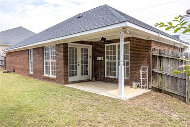 Rear view of property with roof with shingles, a patio area, brick siding, french doors, and a ceiling fan