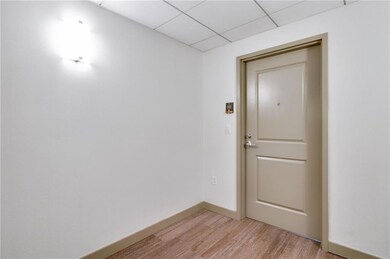 Unfurnished room with light wood-type flooring and a drop ceiling