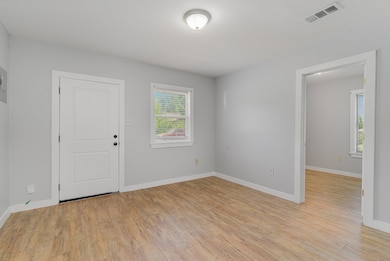 Spare room with baseboards and light wood-style floors