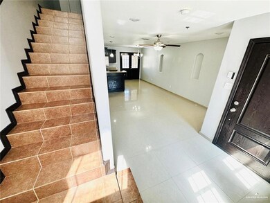 Stairway featuring baseboards, a ceiling fan, and tile patterned floors