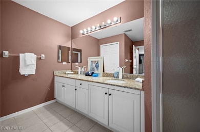 Bathroom featuring double vanity, tile patterned f