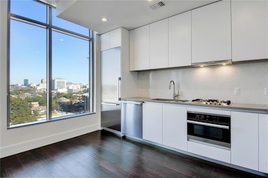 Kitchen with visible vents, white cabinetry, a si