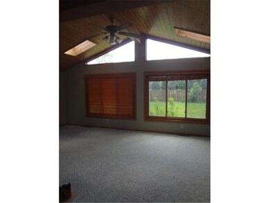 A spacious sun room with vaulted ceiling and large
