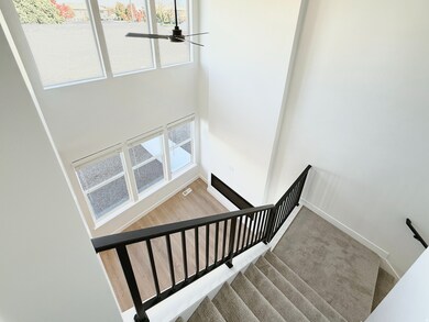 Stairs with a towering ceiling and a ceiling fan