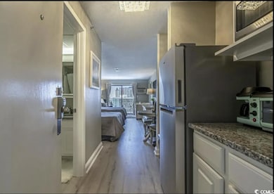 Kitchen with white cabinetry, a toaster, light woo