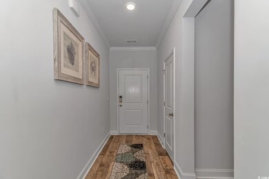 Doorway featuring crown molding, baseboards, light