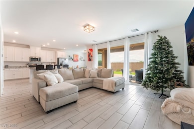 Living area with recessed lighting and light wood