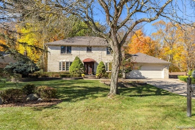 View of front of house featuring brick siding, a garage, and driveway