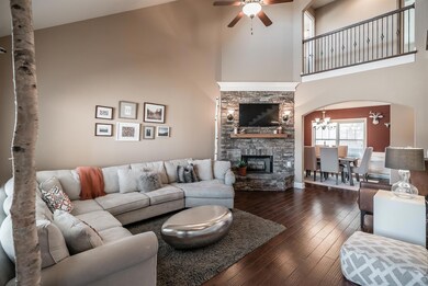 The heart of this home is this Great Room featuring hardwood floors and beautiful stone fireplace!