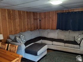 Living area with a drop ceiling and wooden walls
