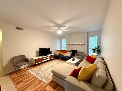 Living area with a brick fireplace, a ceiling fan