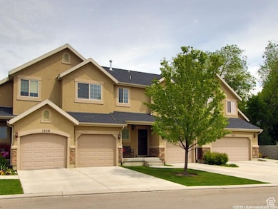 View of front of home featuring driveway, stone siding, a garage, and stucco siding