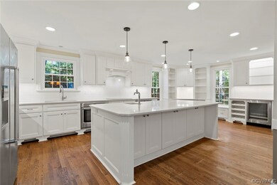 Kitchen with sink, white cabinets, dark hardwood f