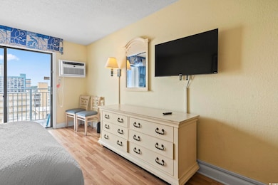 Bedroom featuring access to outside, multiple windows, light wood finished floors, a textured ceiling, and baseboards