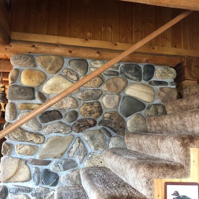 rock wall behind fireplace and side of stairs