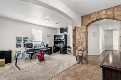 Home office with light carpet and arched walkways