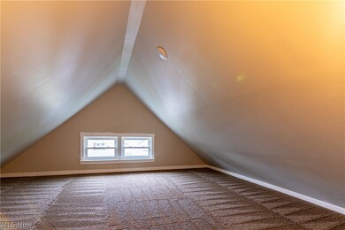Bonus room with carpet flooring and vaulted ceiling