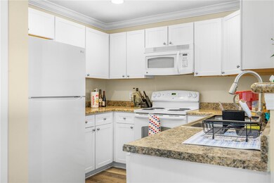 Kitchen featuring white appliances, white cabinetr