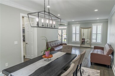 Dining area with wood finished floors, ornamental molding, recessed lighting, and a chandelier