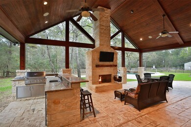 Stunning outdoor kitchen and living area! Vaulted wood ceiling, plus stone fireplace! Stamped concrete patio Plus HUGE bar area complete with refrigerator, grill, cooktop, large sink!
