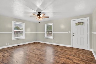 Entrance foyer with dark wood-type flooring, healthy amount of natural light, a textured ceiling, and ceiling fan