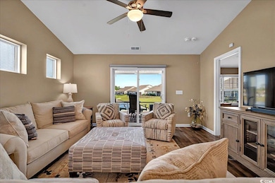 Living area featuring a ceiling fan, wood finished floors, vaulted ceiling, and baseboards