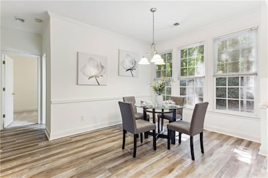Dining room with ornamental molding, light wood-st