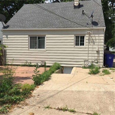 Rear view of patio and drive and crawl space area which houses a newer furnace and hot water tank.
