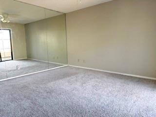 Empty room with carpet floors and ceiling fan
