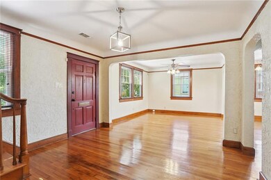 Welcoming entry opens to a spacious living area with rich wood floors and abundant natural light
