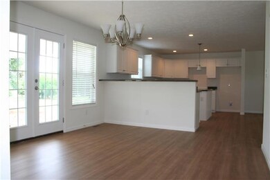 15x12 dining area with double windows, French doors, and chrome fixture. French doors open to carport/patio. Eating bar area at end of kitchen.